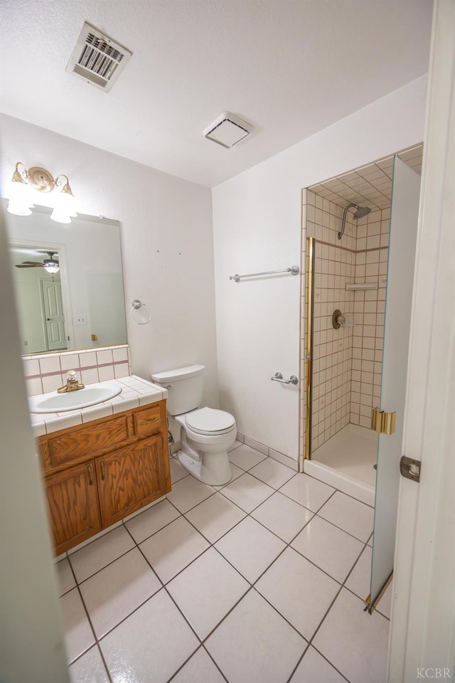 bathroom with vanity, visible vents, tile patterned floors, tasteful backsplash, and a stall shower