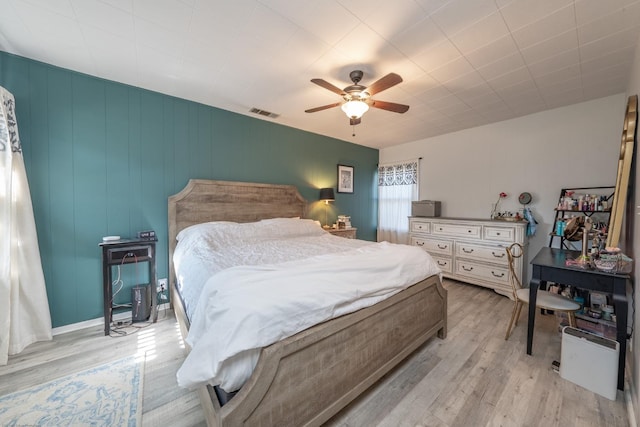 bedroom featuring visible vents, ceiling fan, and light wood-style flooring