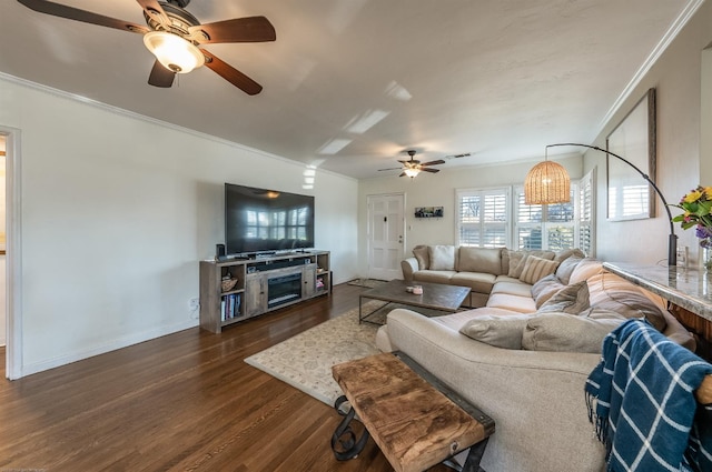 living area with dark wood-type flooring, a fireplace, visible vents, baseboards, and crown molding