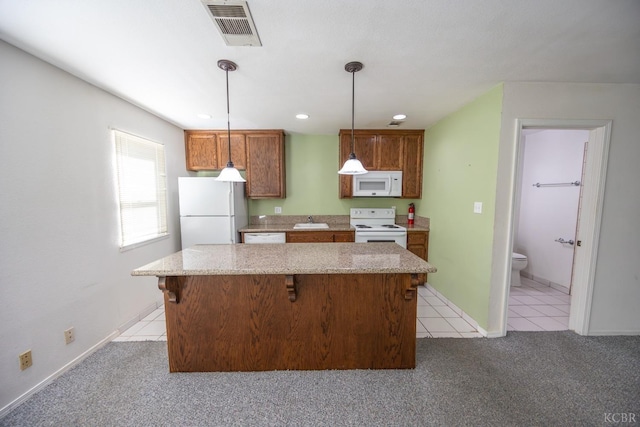 kitchen featuring light carpet, white appliances, a sink, visible vents, and brown cabinets