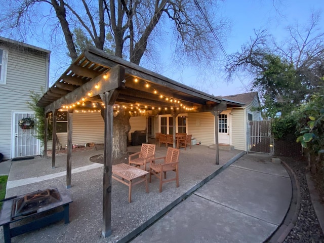 patio terrace at dusk with an outdoor fire pit and a gate