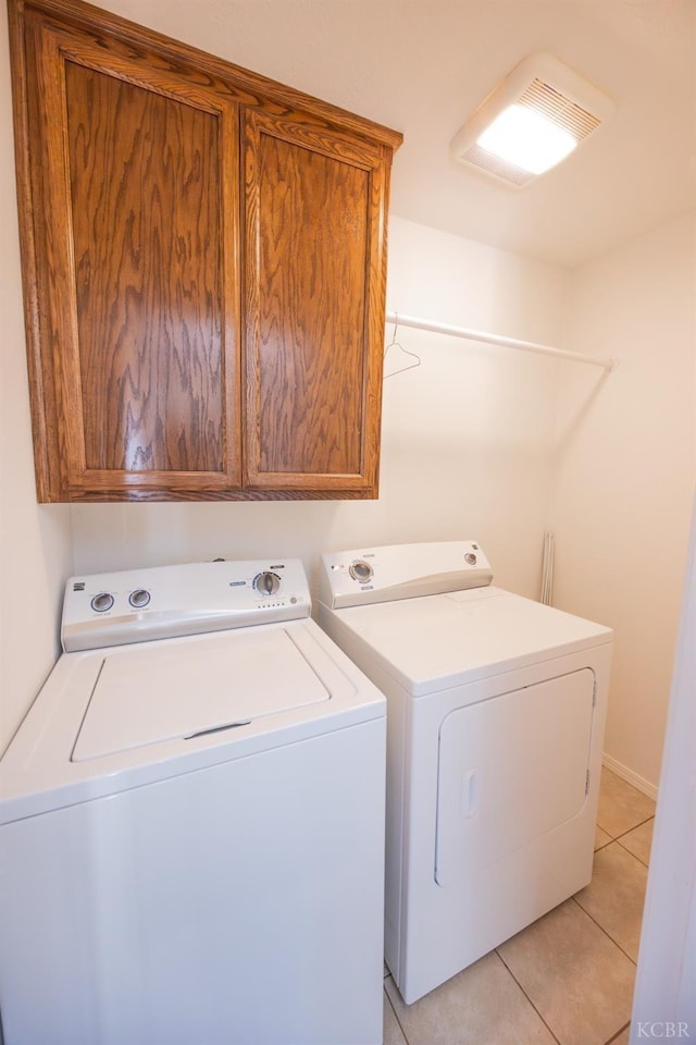 washroom featuring light tile patterned floors, cabinet space, and washer and dryer