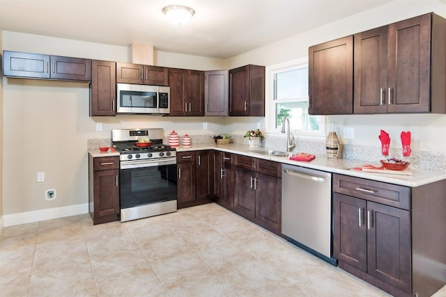 kitchen featuring appliances with stainless steel finishes, dark brown cabinetry, and sink