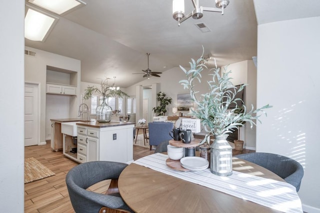 dining room with lofted ceiling, ceiling fan, sink, and light hardwood / wood-style flooring