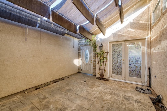 interior space with french doors, beamed ceiling, and a high ceiling