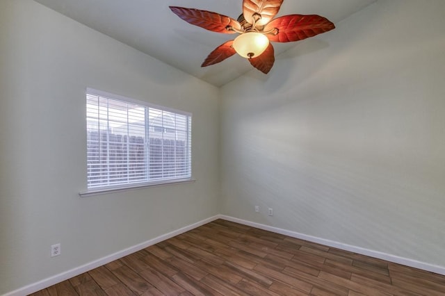 spare room with ceiling fan, vaulted ceiling, and dark wood-type flooring