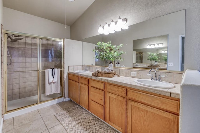 bathroom with tile patterned flooring, walk in shower, and vanity