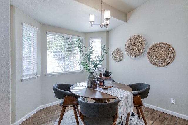 dining area with wood-type flooring and a notable chandelier