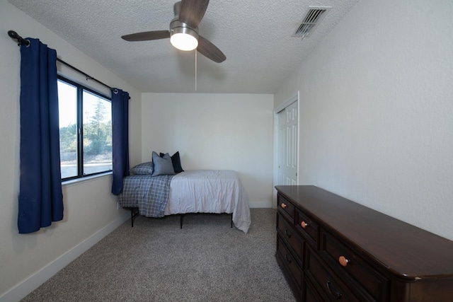 carpeted bedroom with ceiling fan and a textured ceiling