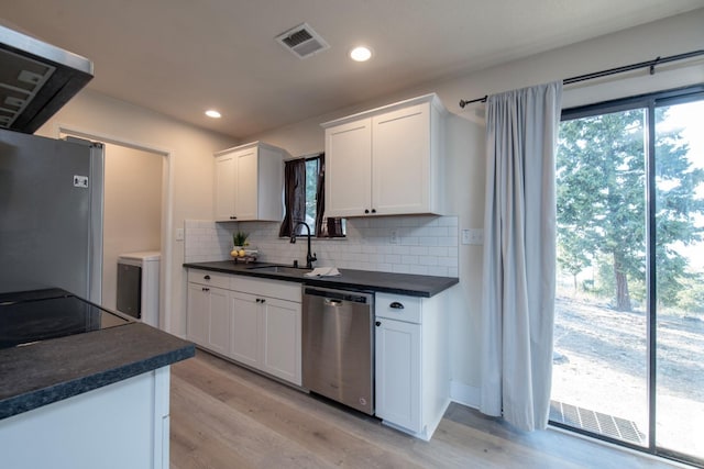 kitchen featuring white cabinetry, stainless steel appliances, tasteful backsplash, sink, and light hardwood / wood-style flooring