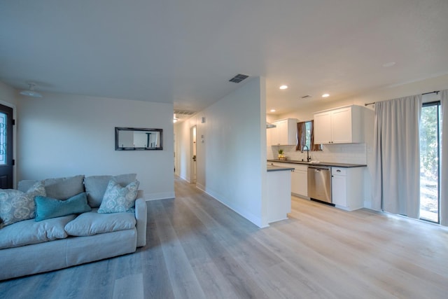 living room featuring light wood-type flooring and sink