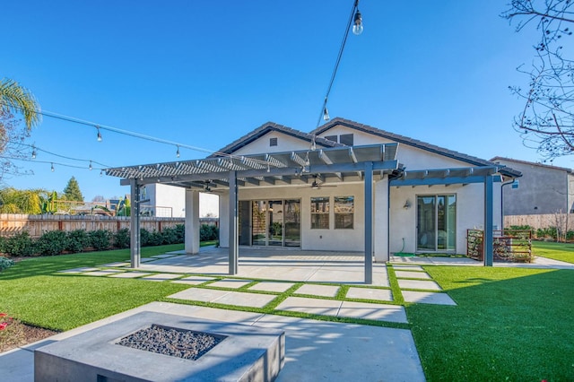 rear view of property with fence, a fire pit, and a lawn