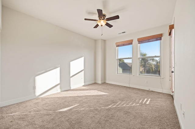 empty room featuring ceiling fan and light carpet