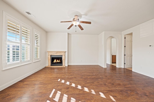 unfurnished living room featuring ceiling fan and dark wood-type flooring