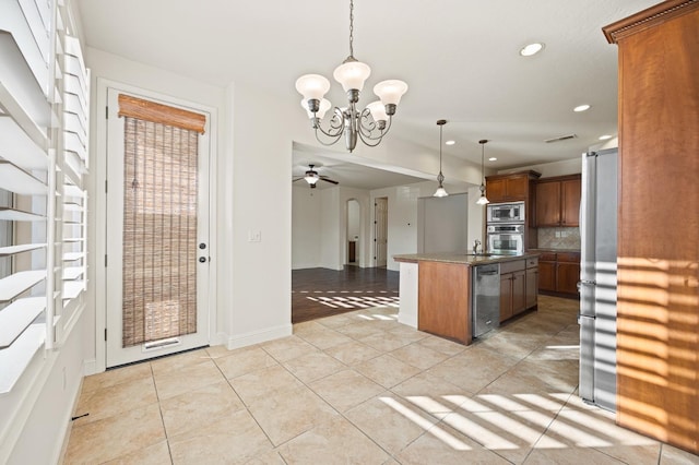 kitchen featuring stainless steel appliances, decorative backsplash, decorative light fixtures, ceiling fan with notable chandelier, and a center island