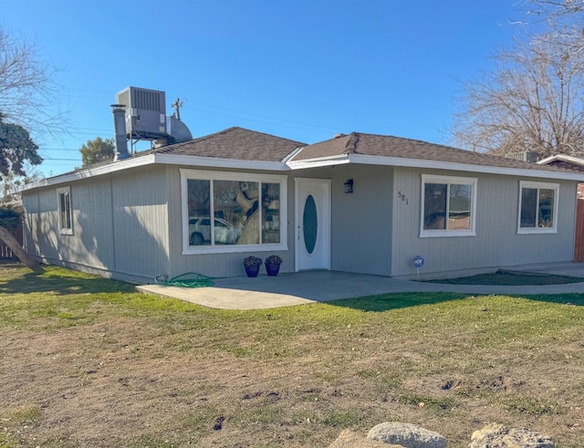 view of front of home featuring a patio, a front lawn, and central AC