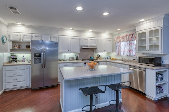 kitchen featuring a center island, sink, stainless steel appliances, and white cabinetry