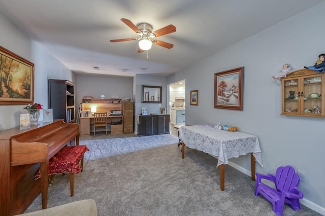 dining area with ceiling fan and light colored carpet