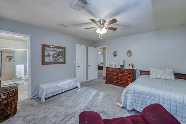 carpeted bedroom with ceiling fan and ensuite bath