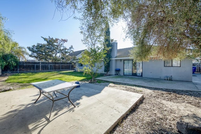 back of property featuring a patio area and a yard