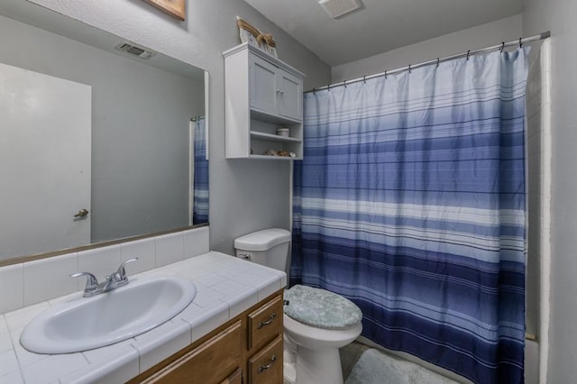 bathroom featuring toilet, vanity, and a shower with curtain