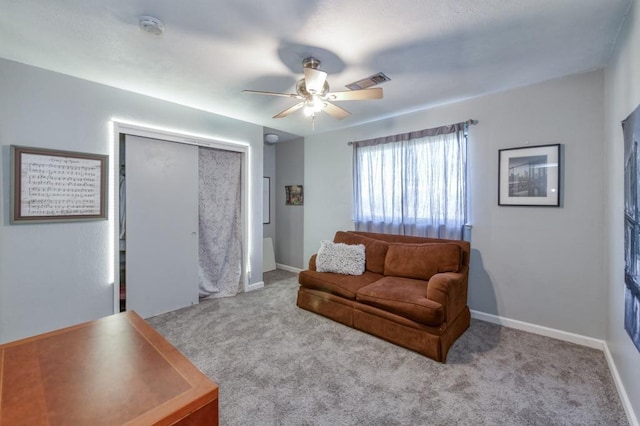 carpeted living room with ceiling fan