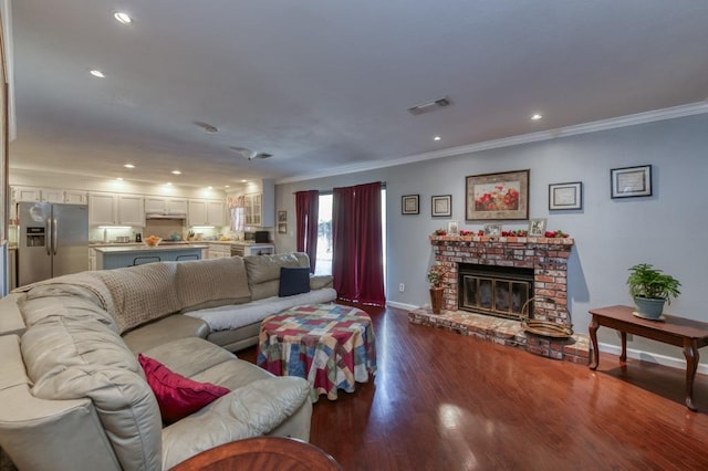 living room with wood-type flooring, a fireplace, and crown molding