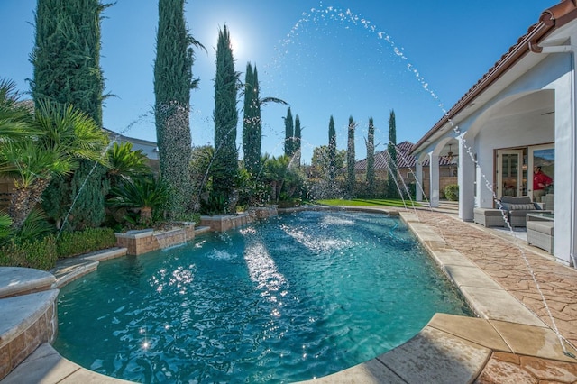 view of swimming pool featuring pool water feature and a patio