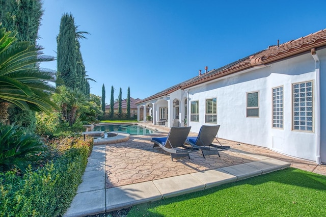 view of patio with a swimming pool with hot tub