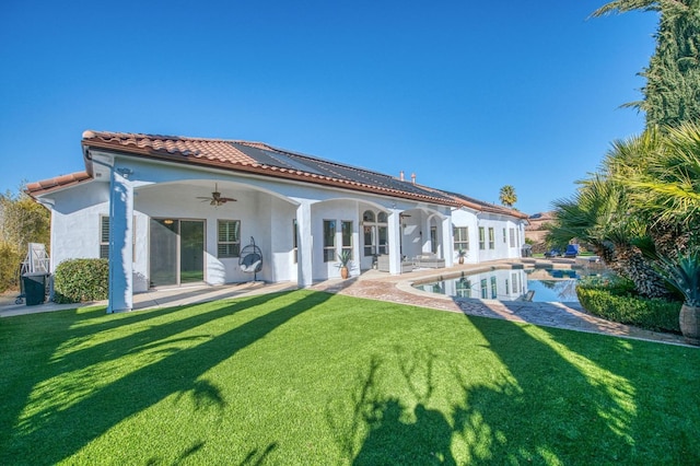 back of property featuring ceiling fan, a yard, and a patio