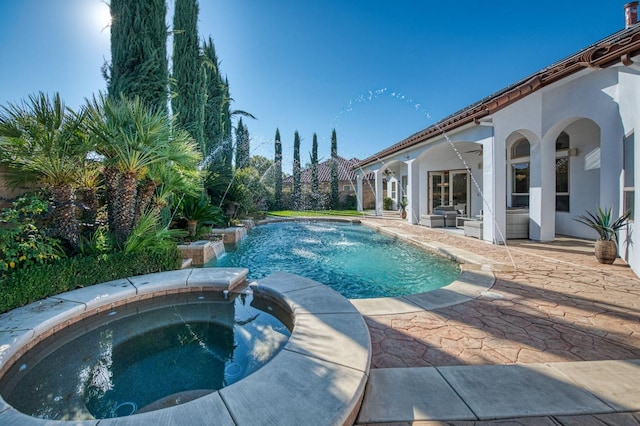 view of pool with an in ground hot tub, a patio area, and pool water feature