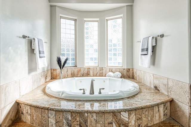 bathroom featuring tiled tub and breakfast area