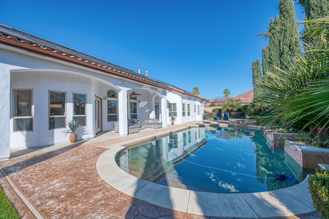 view of swimming pool with ceiling fan and a patio area