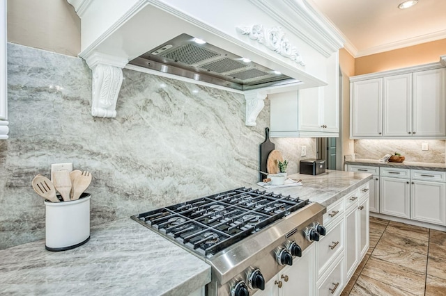 kitchen featuring backsplash, stainless steel gas stovetop, custom exhaust hood, crown molding, and white cabinets