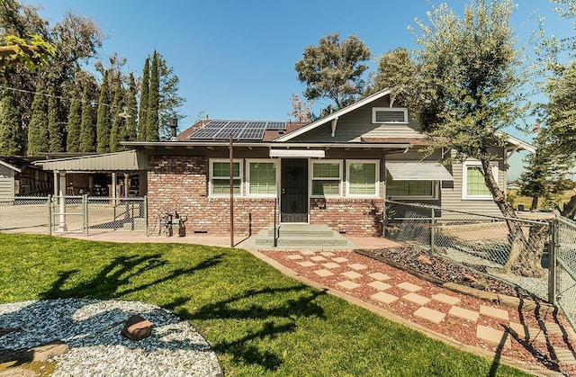 view of front facade featuring a front yard and solar panels