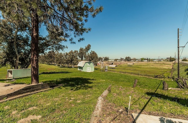 view of yard featuring a storage shed and a rural view