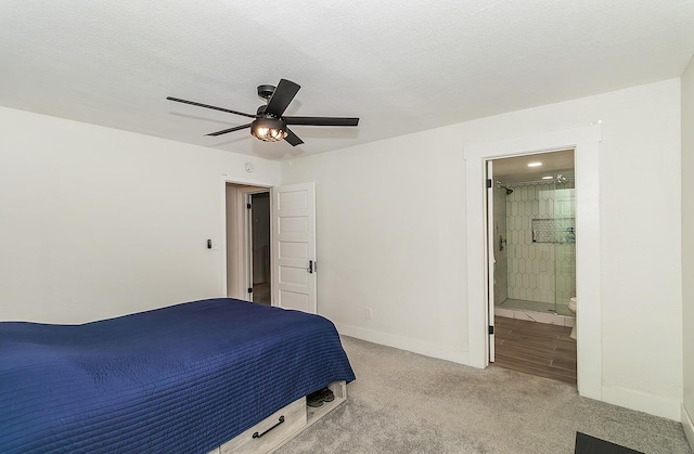 carpeted bedroom featuring ensuite bathroom, ceiling fan, and a textured ceiling