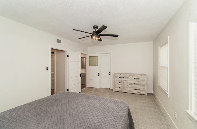 unfurnished bedroom with ceiling fan, light carpet, a closet, and a textured ceiling