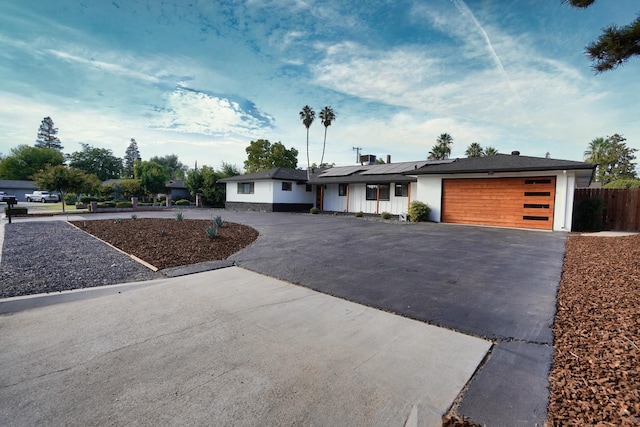 ranch-style house with solar panels and a garage