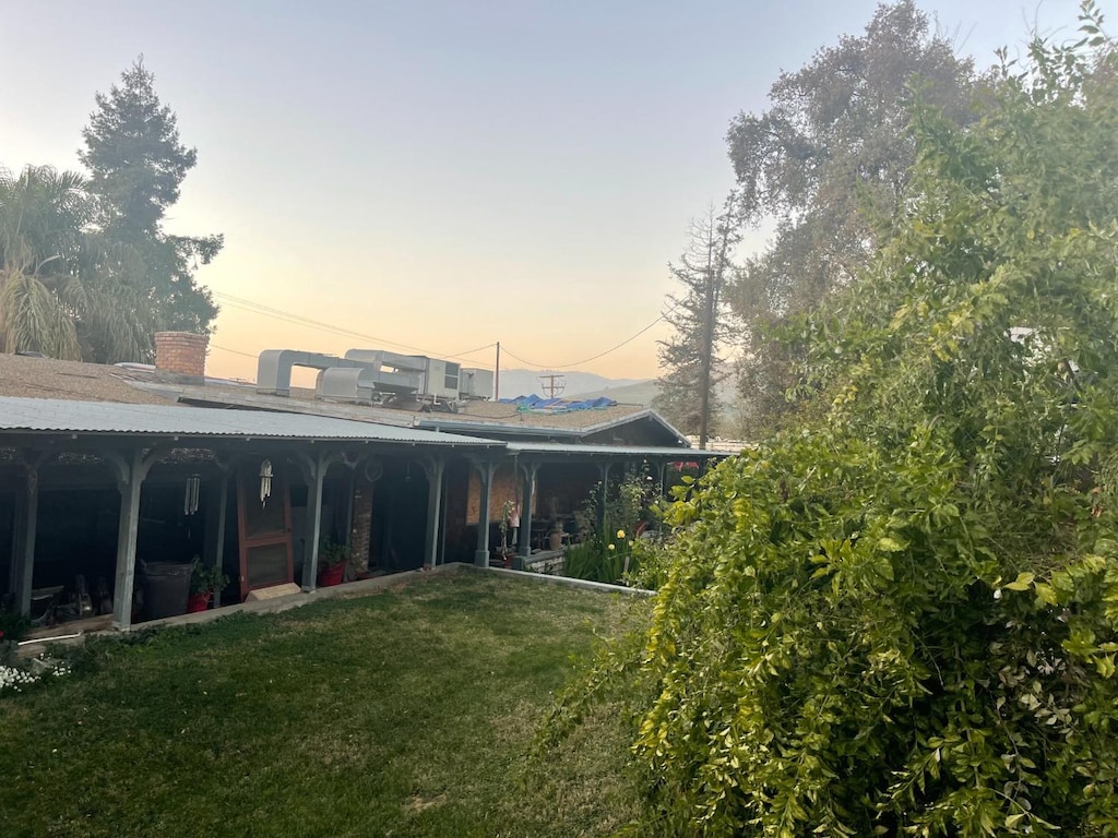 back house at dusk with a lawn