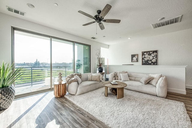 living room featuring visible vents, a textured ceiling, and wood finished floors