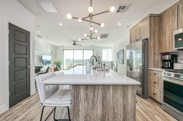 kitchen with stainless steel appliances, visible vents, and brown cabinets