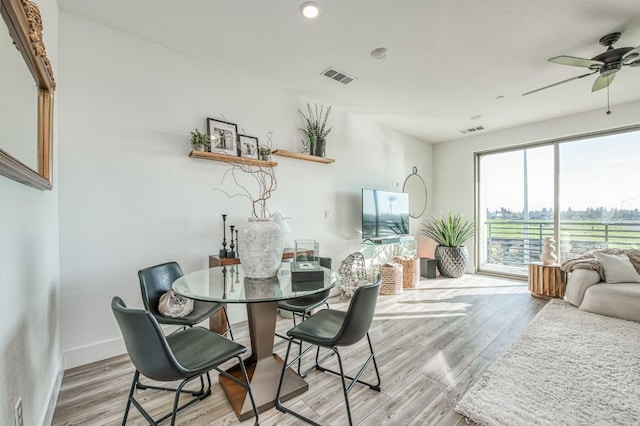 dining space featuring visible vents, ceiling fan, light wood-style flooring, and baseboards