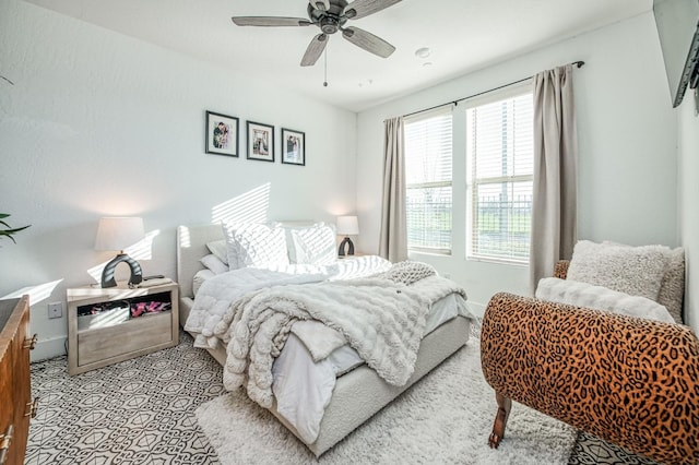 bedroom featuring a ceiling fan, light carpet, and baseboards