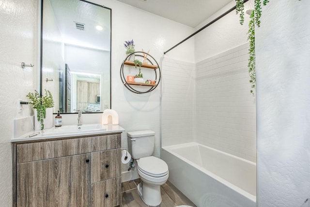 bathroom with visible vents, toilet, wood finished floors,  shower combination, and vanity