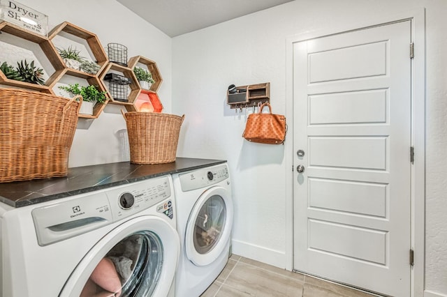 washroom with laundry area, washing machine and dryer, and baseboards