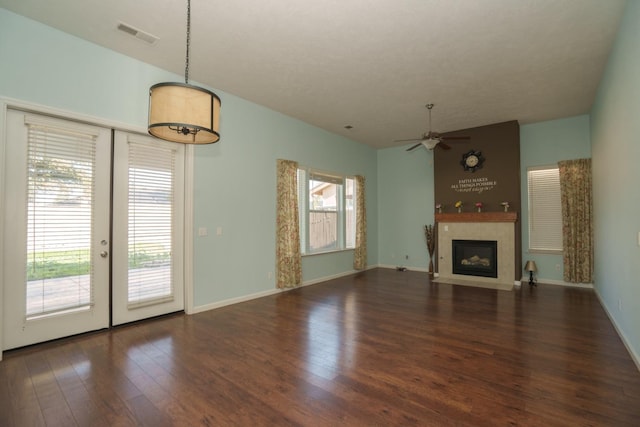 unfurnished living room with ceiling fan, dark wood-type flooring, and french doors