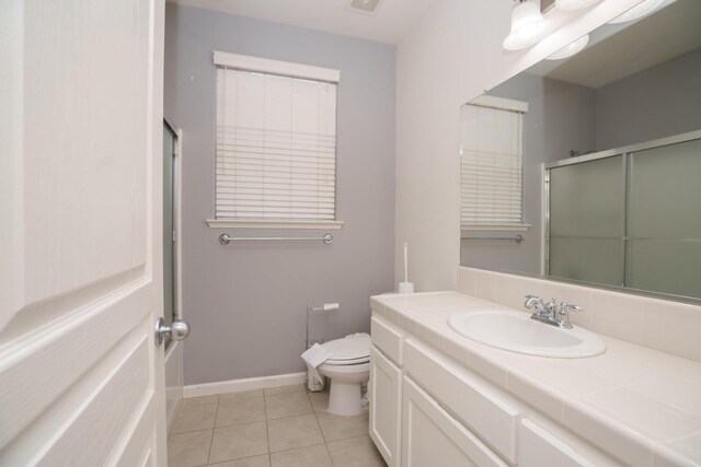 bathroom with toilet, tile patterned floors, an enclosed shower, and vanity