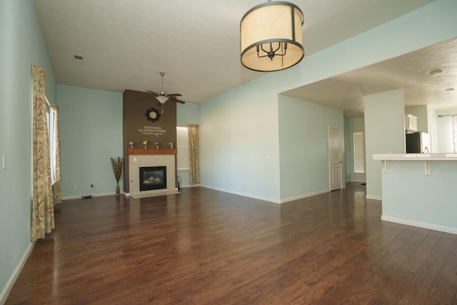 unfurnished living room with ceiling fan and dark hardwood / wood-style floors