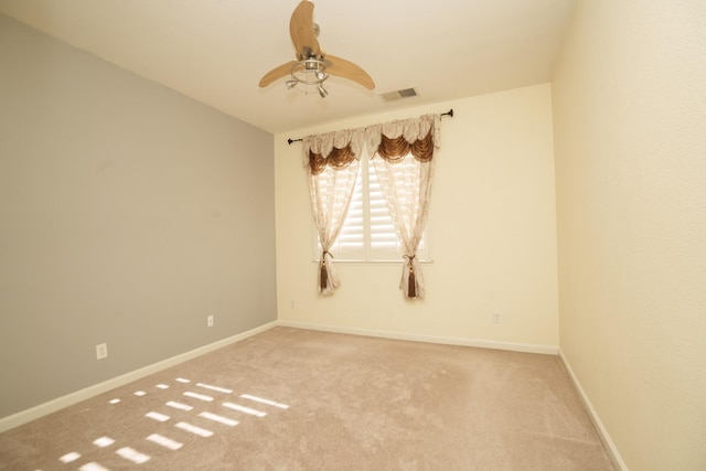 empty room featuring ceiling fan and carpet